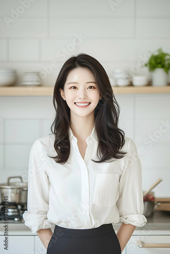 Smiling Young Woman Wearing Apron in a Bright Modern Kitchen