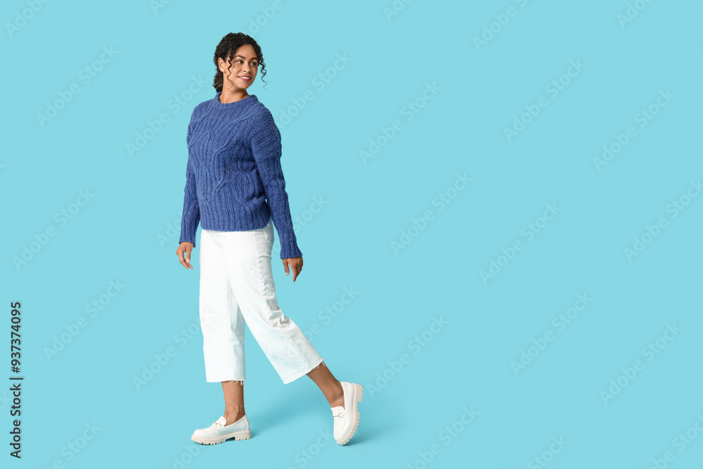 Beautiful young happy African-American woman in autumn outfit on blue background Beautiful young happy African-American woman in autumn outfit on blue background