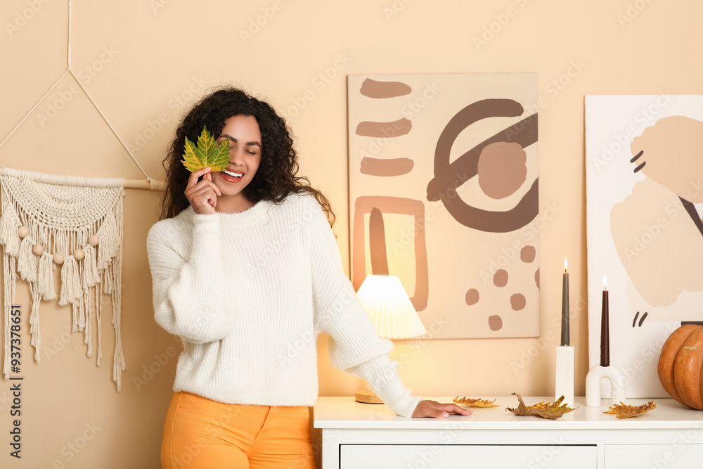 Φωτογραφία Beautiful young happy African-American woman in stylish outfit with autumn leave