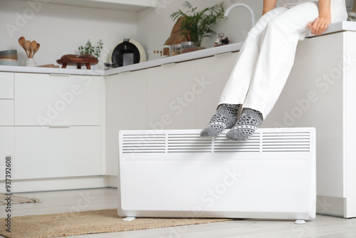 Woman warming feet on elect...