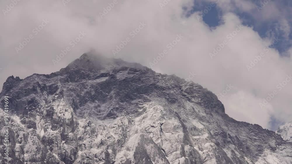 Mystic clouds flying around snowy and icy Mount Everest mountain in Nepal. Sunny day with blue sky in summer. Bottom up wide shot time lapse. Mystic clouds flying around snowy and icy Mount Everest mountain in Nepal. Sunny day with blue sky in summer. Bottom up wide shot time lapse.