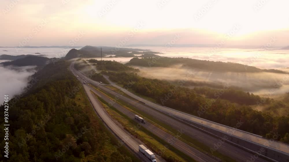 Aerial shot of the sunrising over the fog and highway cutting through the Smoky Mountains. Aerial shot of the sunrising over the fog and highway cutting through the Smoky Mountains.