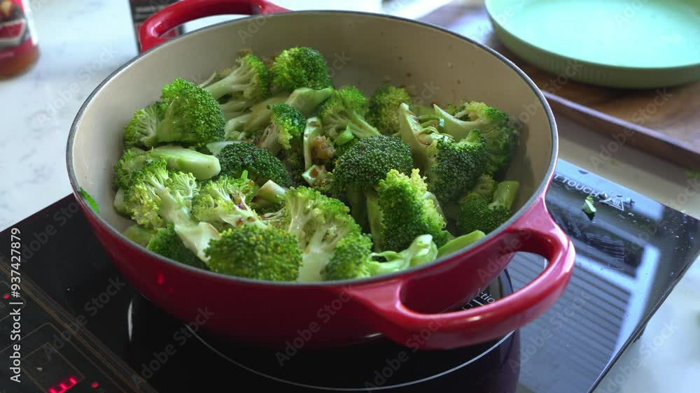 Broccoli being cooked inside of a red cast iron pan special ingredients to cook a meal two cans of beans rice plantain avocado red onion and cilantro Broccoli being cooked inside of a red cast iron pan special ingredients to cook a meal two cans of beans rice plantain avocado red onion and cilantro