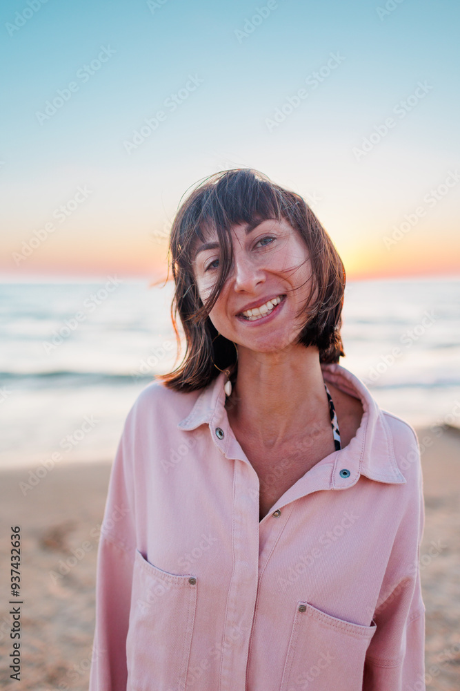 Summer mood. girl on the beach. happy young girl in a pink shirt and swimsuit resting on the beach. sunset near the sea. the girl is standing on the beach. Summer mood. girl on the beach. happy young girl in a pink shirt and swimsuit resting on the beach. sunset near the sea. the girl is standing on the beach.