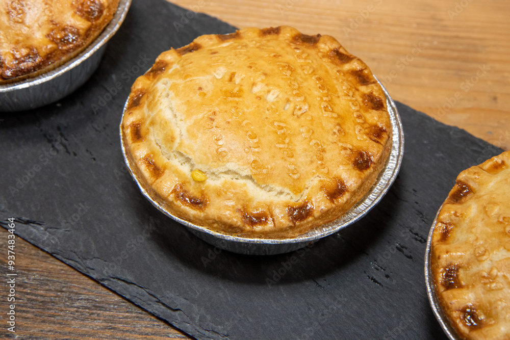 A trey or freshly baked meat and vegetable pies on a wooden kitchen table A trey or freshly baked meat and vegetable pies on a wooden kitchen table