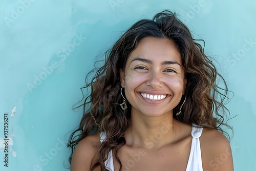 Radiant Woman Smiling Brightly Against Turquoise Wall