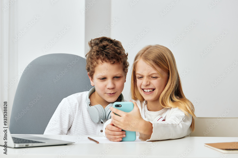 Happy Caucasian Boy and Girl Studying and Playing Online Education Games at Home with Laptop and Tablet Happy Caucasian Boy and Girl Studying and Playing Online Education Games at Home with Laptop and Tablet