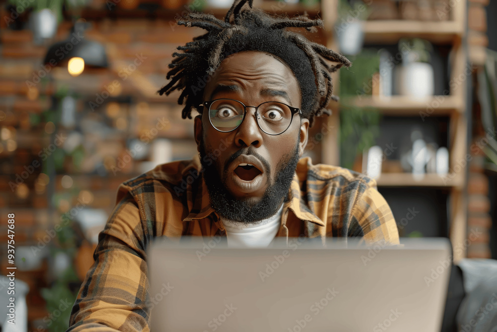 Surprised Man With Glasses And Dreadlocks Staring At Laptop In Rustic Environment Surprised Man With Glasses And Dreadlocks Staring At Laptop In Rustic Environment