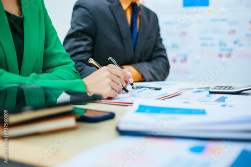 A group of professional business men and women are having a constructive meeting, discussing strategies, exchanging ideas and making decisions in a modern organization. They are wearing formal suits.
 photo