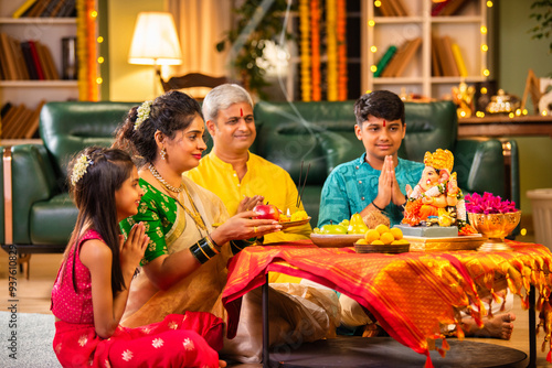 Photos Indian family celebrating Ganesh Chaturthi, performing puja with traditional rit