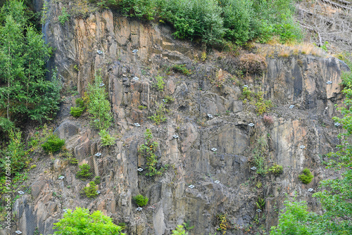 Securing a natural rock face with nets against falling rocks