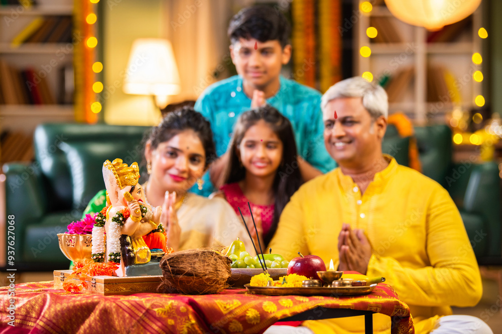 Indian family celebrating Ganesh Chaturthi, performing puja with ...