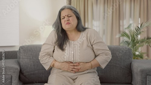 Sick Indian old woman suffering from stomach pain