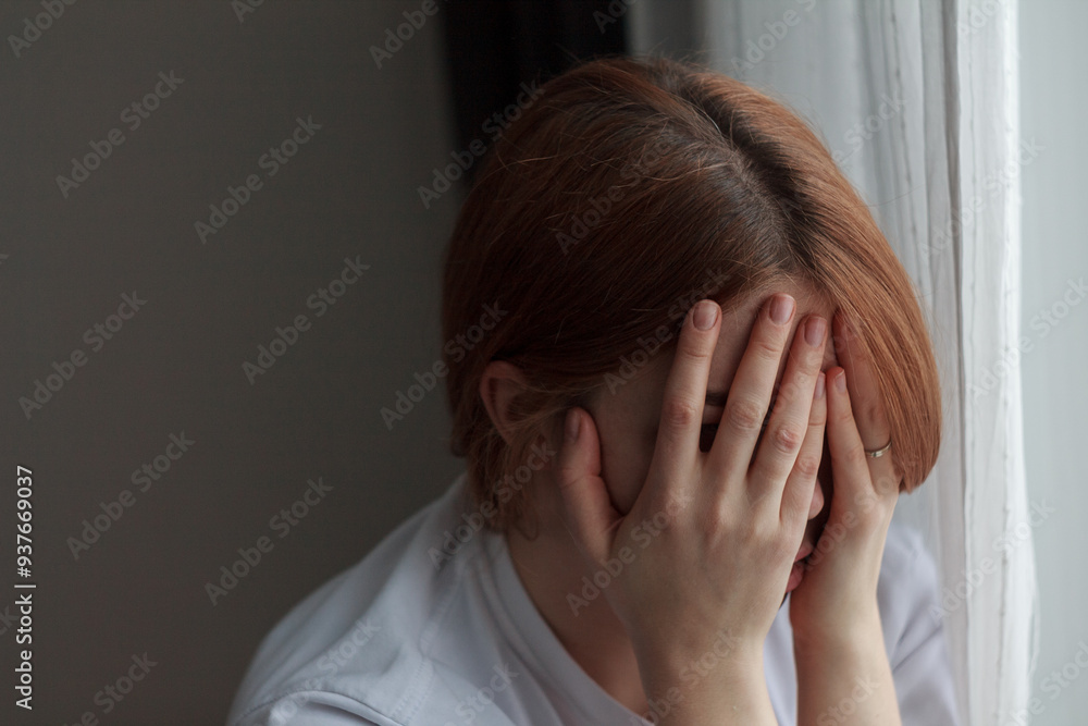 Portrait of a depressed woman: pale face, downcast eyes, expression of sadness and fatigue, shadows under the eyes, disheveled hair, blurred and dark Portrait of a depressed woman: pale face, downcast eyes, expression of sadness and fatigue, shadows under the eyes, disheveled hair, blurred and dark