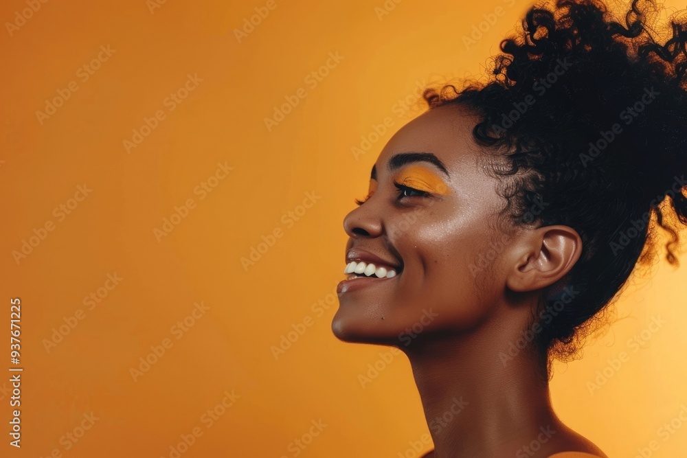 Smiling young black woman in studio with makeup against orange background. Smiling young black woman in studio with makeup against orange background.