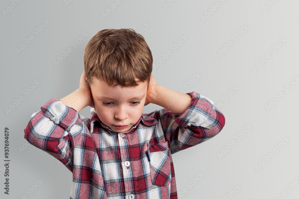 The boy covers his ears with his hands, expressing his reluctance to hear noise, conveying feelings of vulnerability and security The boy covers his ears with his hands, expressing his reluctance to hear noise, conveying feelings of vulnerability and security