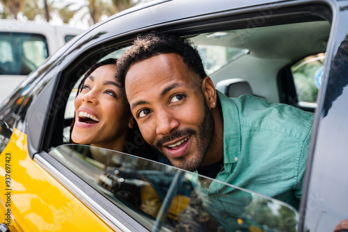 Canvas Print Happy hispanic latino couple taking a taxi - Tourists driving on car and visitin