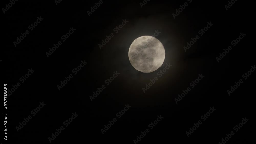 Moon rising at night. Gray clouds moving in front of the moon. Moon rising at night. Gray clouds moving in front of the moon.