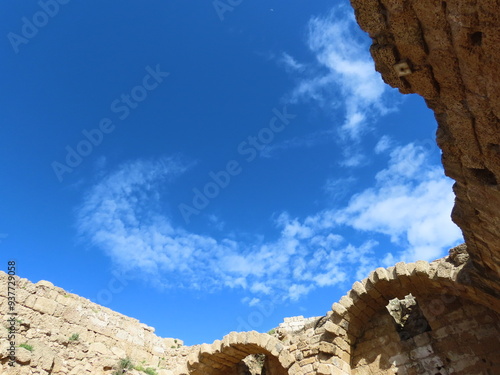 Beautiful view from the ruins of an ancient city in Caesarea in Israel to a blue sky and a crescent of white clouds. An interesting journey through historical sights.