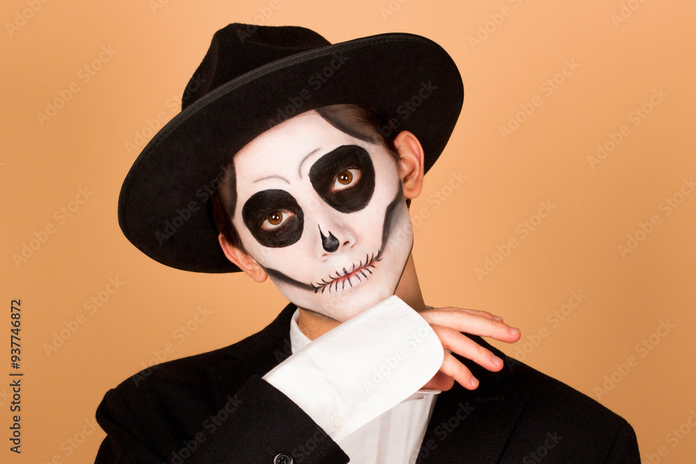 Portrait of man in suit with flower in pocket on beige background, with Halloween skull make up showing his emotions. Halloween or horror theme Portrait of man in suit with flower in pocket on beige background, with Halloween skull make up showing his emotions. Halloween or horror theme