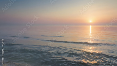 This image could be named Evening Sunset Over the Sea with Orange Sky and Gentle Waves on the Beach