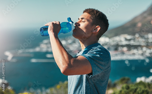 Fitness, man and drinking water outdoor for wellness, body health and nutrition benefits after exercise. Hydration, bottle and thirsty runner in nature with liquid for electrolytes on break or rest photo