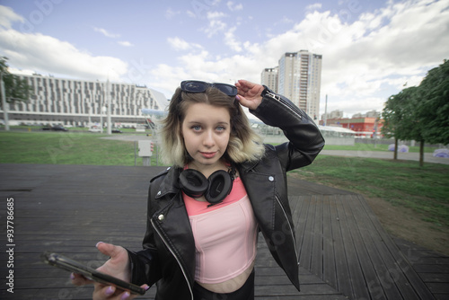 Portrait of a young beautiful girl in dark clothes in an urban environment.