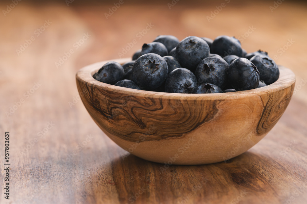 Fresh blueberries in wood bowl on table slightly toned Fresh blueberries in wood bowl on table slightly toned
