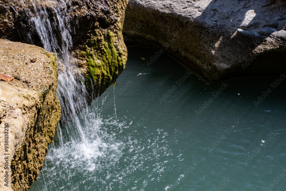 Naklejka premium 岩のすき間から水が流れ落ちる
