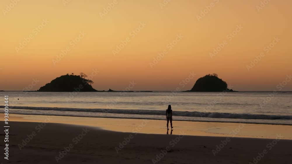 Aerial view of a silhouette woman walking on a tropical beach island with beautiful orange sunset sky. Travel video of woman relaxing in vacation in Nacpan beach Philippines Aerial view of a silhouette woman walking on a tropical beach island with beautiful orange sunset sky. Travel video of woman relaxing in vacation in Nacpan beach Philippines