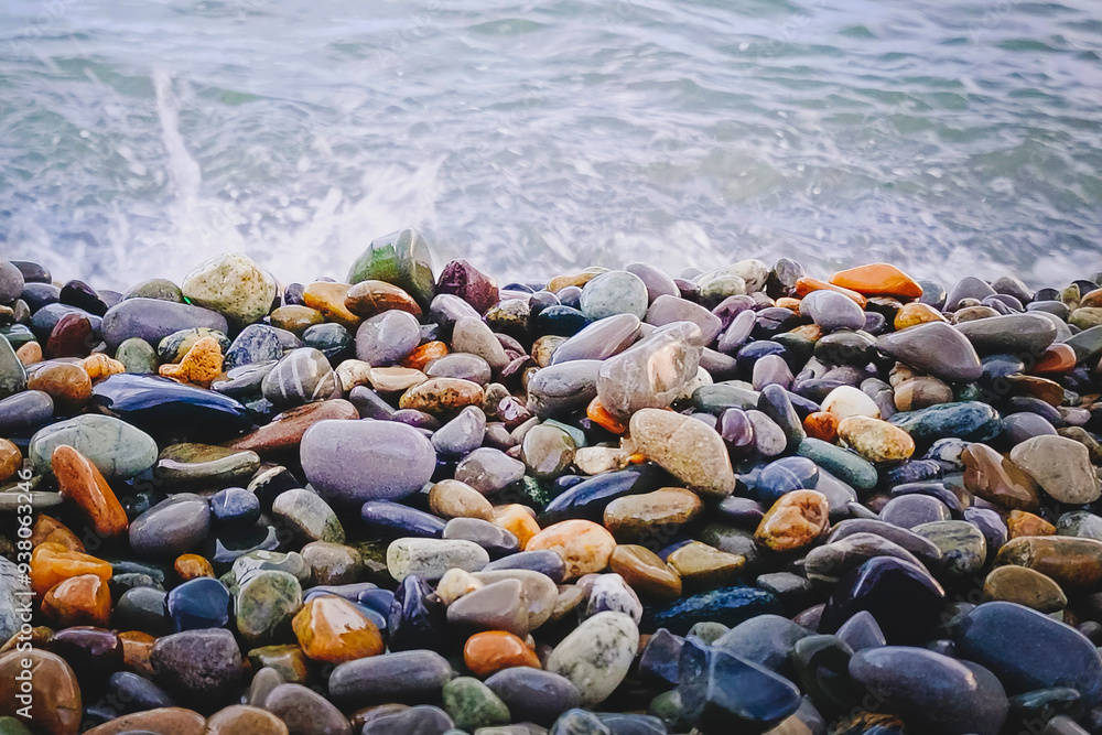 Abstract background with pebbles - round sea stones. Wet sea pebbles washed by sea waves. Abstract background with pebbles - round sea stones. Wet sea pebbles washed by sea waves.