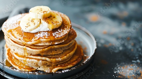 Delectable stack of fluffy golden pancakes adorned with a variety of tempting toppings like sliced banana honey drizzle and fresh whipped cream served on a rustic plate against a dark background photo