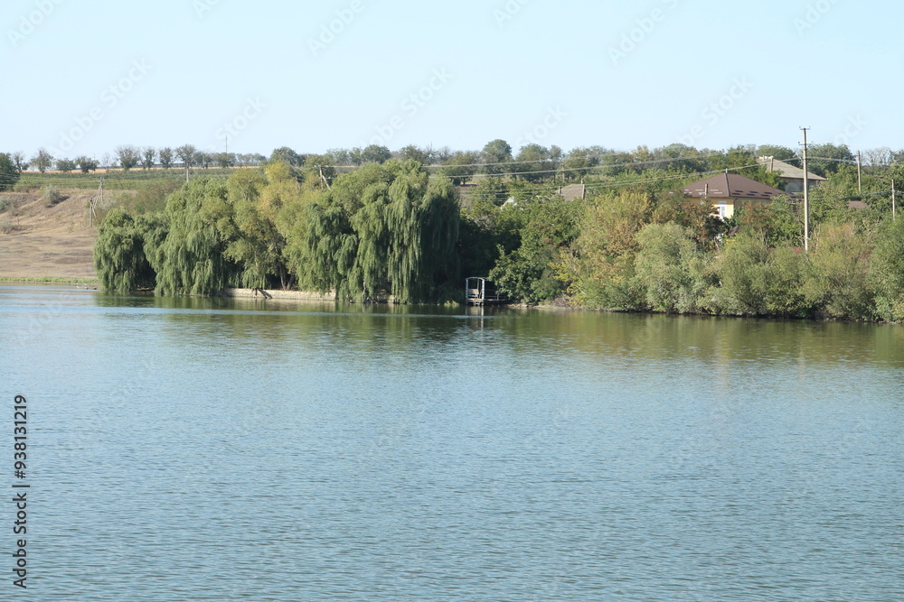 A lake with trees and a house A lake with trees and a house