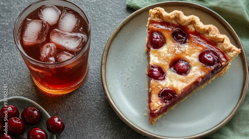 Refreshing iced tea and cherry pie on a table with fresh cherries and green leaves photo