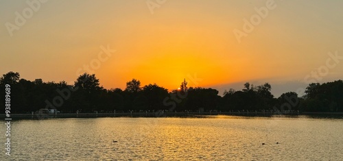 Beautiful sunset with golden sky in front of a lake in Madrid, Spain photo