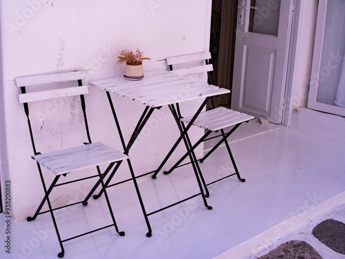 Terraza con mesa y sillas, todo de color blanco, en Naoussa, Paros