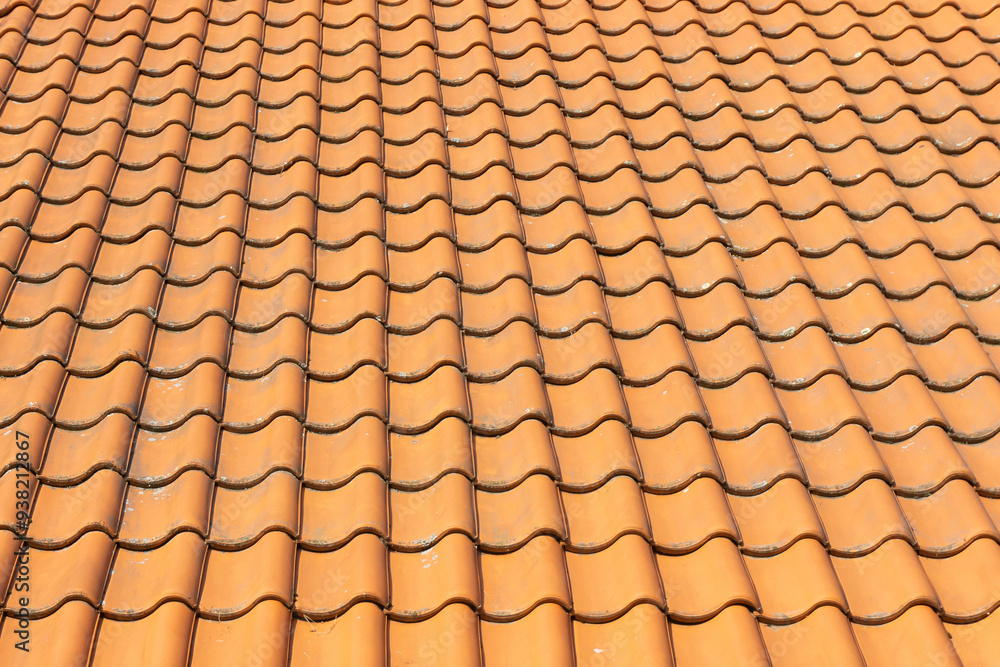 Orange tiled roof with traditional clay roofing tiles. Detailed pattern and texture in residential architecture. Terracotta tiles background. Structure and design of the roof. Orange tiled roof with traditional clay roofing tiles. Detailed pattern and texture in residential architecture. Terracotta tiles background. Structure and design of the roof.