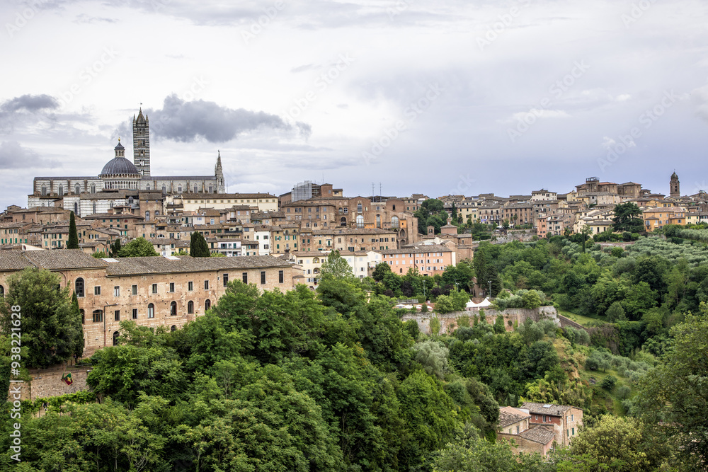 Naklejka premium Ogólna panorama Sienny w letnie pochmurne popołudnie z widokiem katedry na pierwszym planie