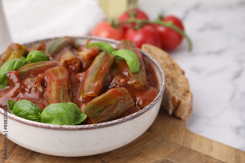 Tasty stew with okra, tomato sauce and basil on white marble table, closeup Tasty stew with okra, tomato sauce and basil on white marble table, closeup