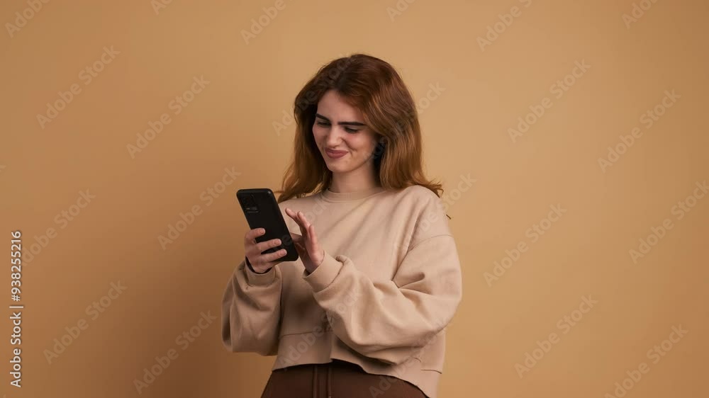 Young woman distracted using phone and smiling Young woman distracted using phone and smiling