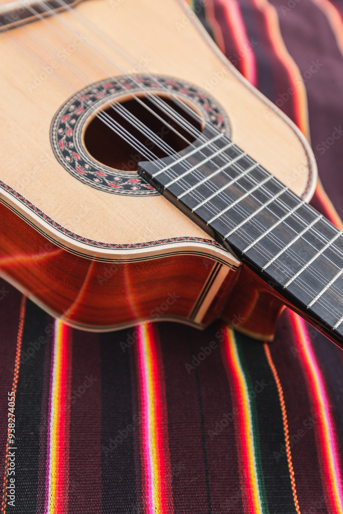 Obraz premium Traditional Andean instruments elegantly arranged on a striped textile. The Charango, Mandolin, and Bandolina are artfully crossed, highlighting their fine details and cultural significance.