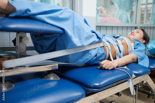 Quadro em tela Patient lying on a Mechanical traction physio bed with belt strapped around the body, decompression of the tension taking pressure of the joints and spine pain relief