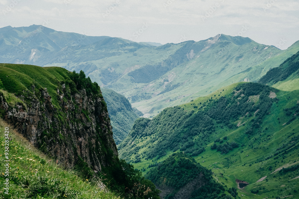 Breathtaking view of a green mountain valley with steep cliffs and rolling hills under a cloudy sky. Perfect for nature, travel, and adventure themes. High-quality, scenic landscape. Breathtaking view of a green mountain valley with steep cliffs and rolling hills under a cloudy sky. Perfect for nature, travel, and adventure themes. High-quality, scenic landscape.