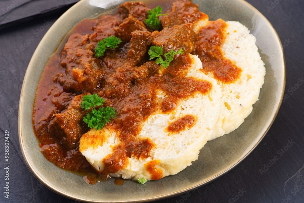Beef goulash and dumplings (knedliky) on table Beef goulash and dumplings (knedliky) on table
