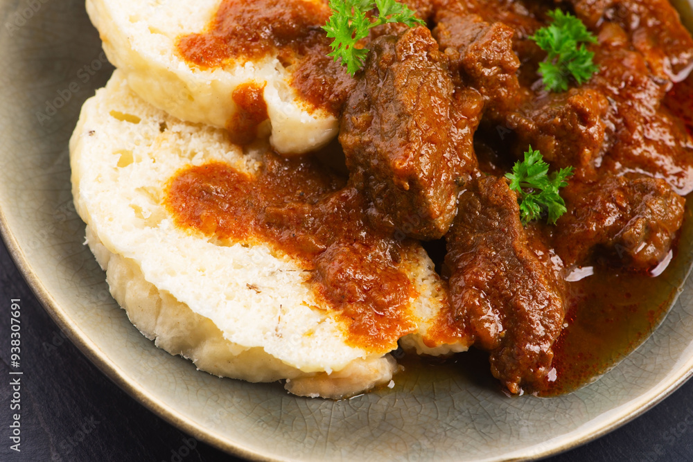 Beef goulash and dumplings (knedliky) on table Beef goulash and dumplings (knedliky) on table