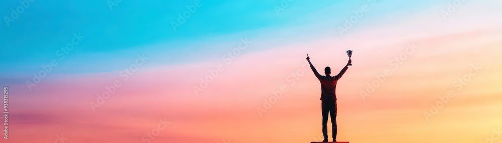 Silhouette of a person holding a trophy up in the air against a colorful sunset. Silhouette of a person holding a trophy up in the air against a colorful sunset.