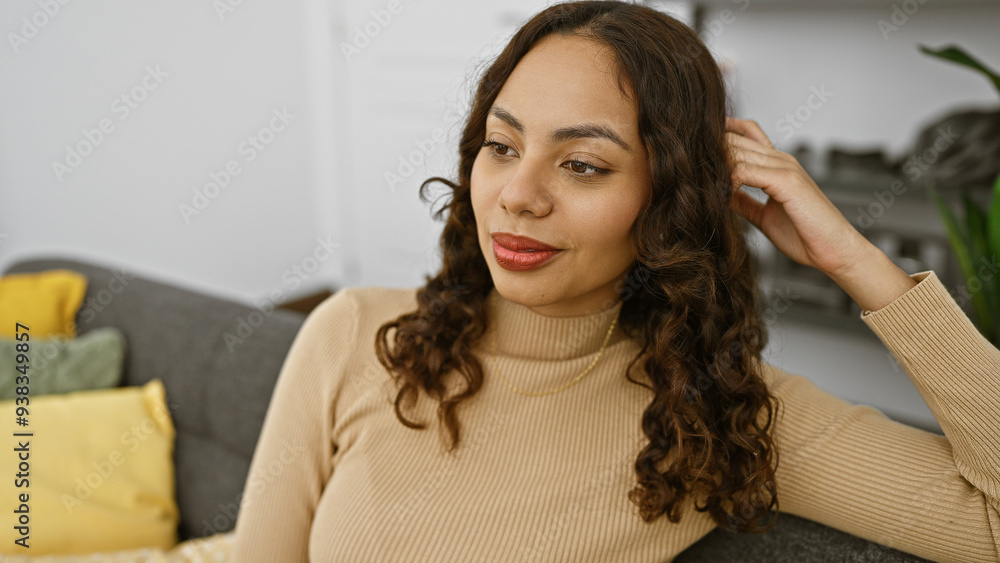 A young adult mixed race woman poses casually indoors, exuding a relaxed, confident vibe in a well-lit living room. A young adult mixed race woman poses casually indoors, exuding a relaxed, confident vibe in a well-lit living room.