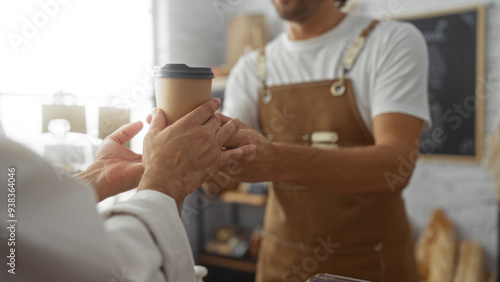 Εκτύπωση καμβά Men in a bakery exchanging a coffee cup with the baker wearing a brown apron and