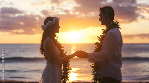 A romantic silhouette of a couple holding hands during a stunning sunset on the beach, adorned with floral leis. 