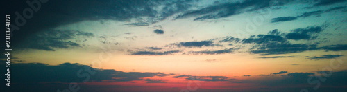 Sunset casting a warm glow over a plowed field and cloudy sky.